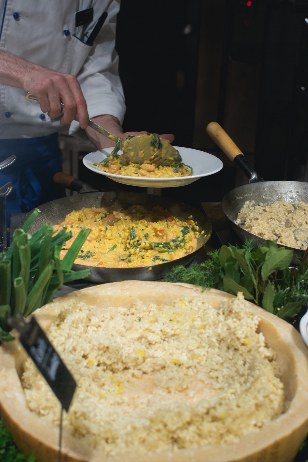 A cook scooping a fresh dish in the kitchen
